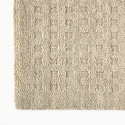 Smooth champagne beige rectangle over cream looped shag rug; warm modern home decor texture.