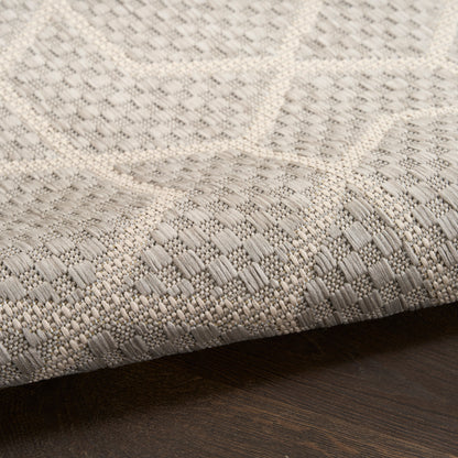 Neutral woven runner rug with geometric square pattern in cream and gray on dark wood floor