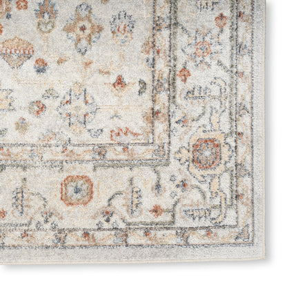 Cream Persian-style rug with blue and rust floral motifs and a decorative border; soft textured pile. Vintage 7' x 9'.