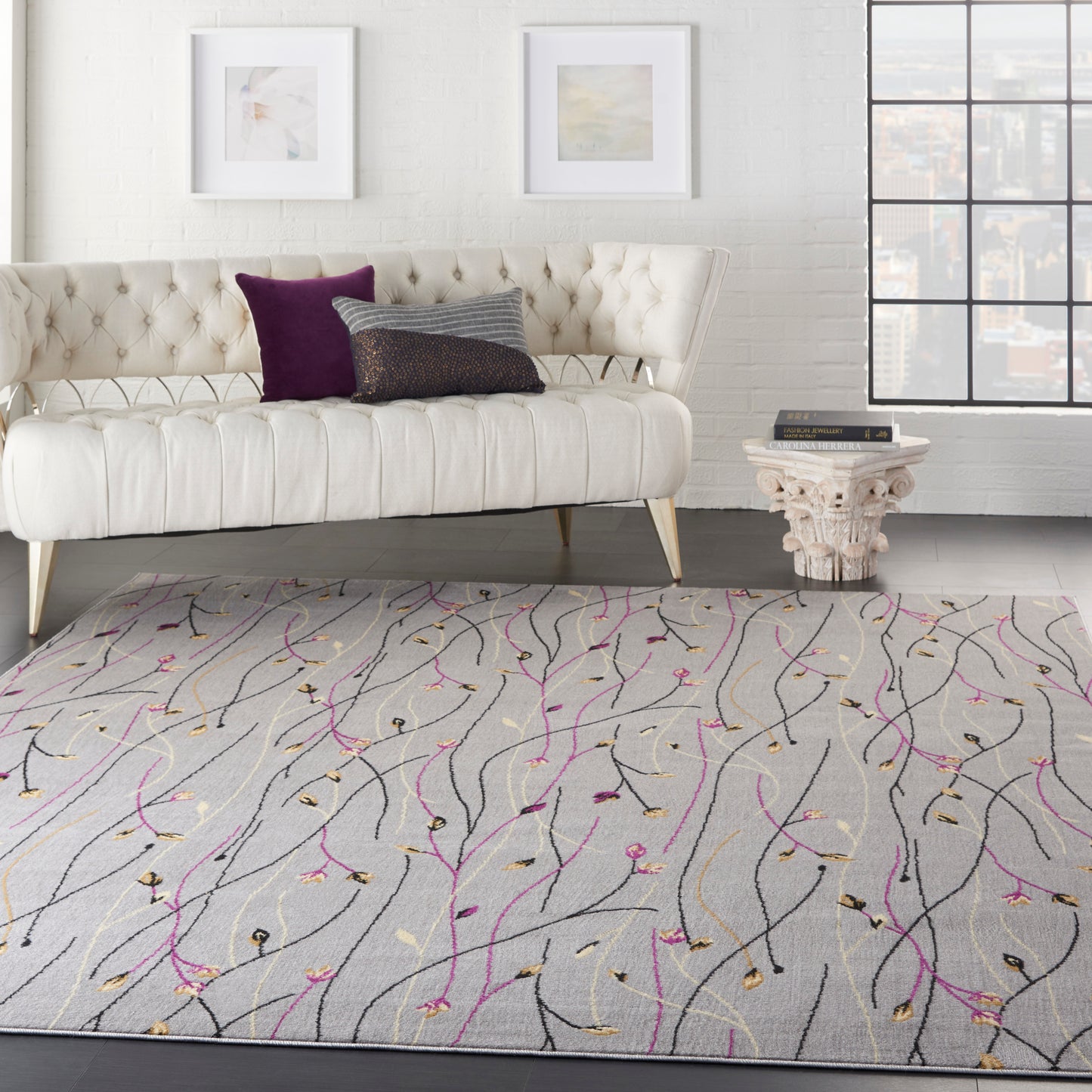 Light gray abstract area rug with black, magenta and gold vine-like lines in a modern living room setting.
