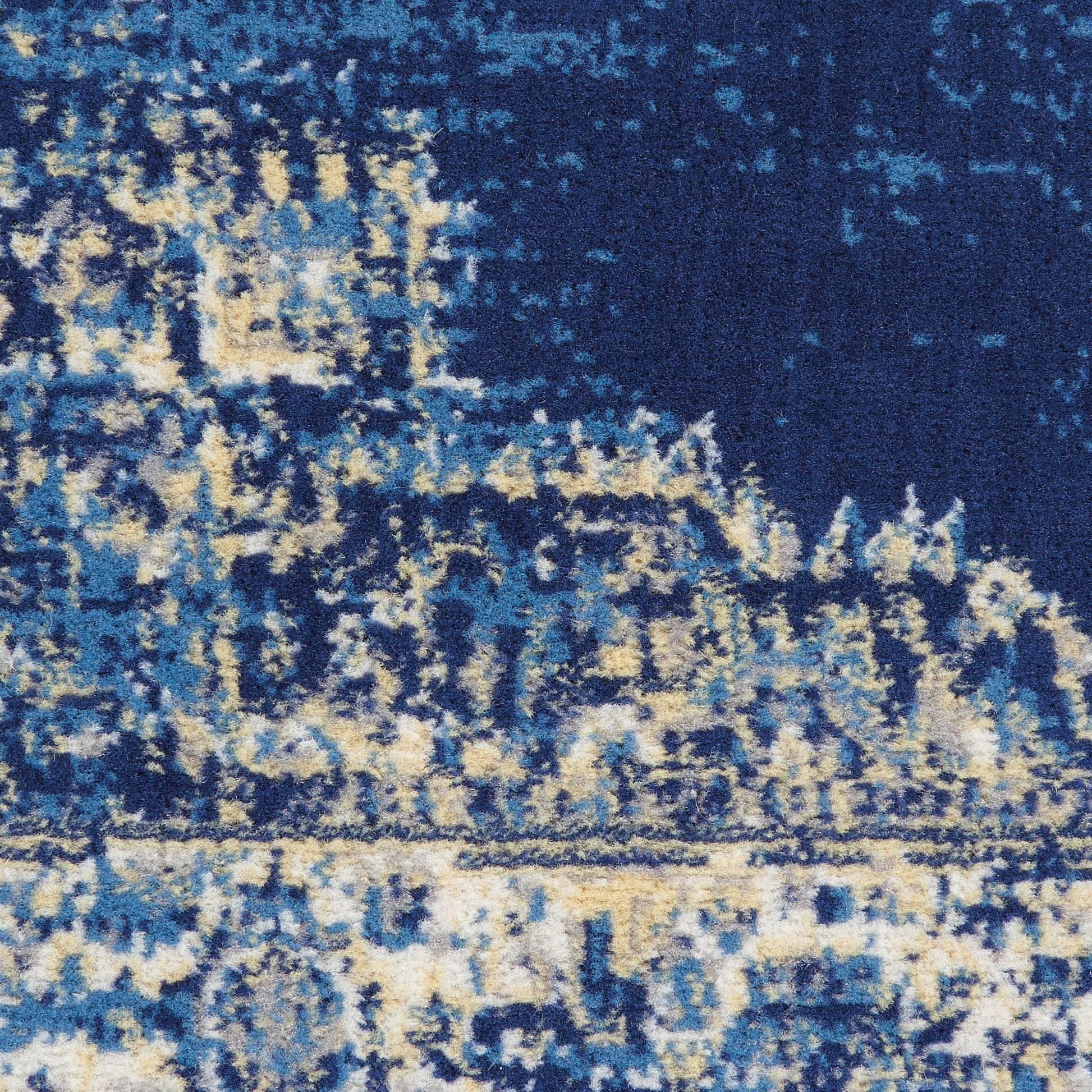 Blue abstract area rug with navy, sky blue and cream tones in a distressed modern pattern.