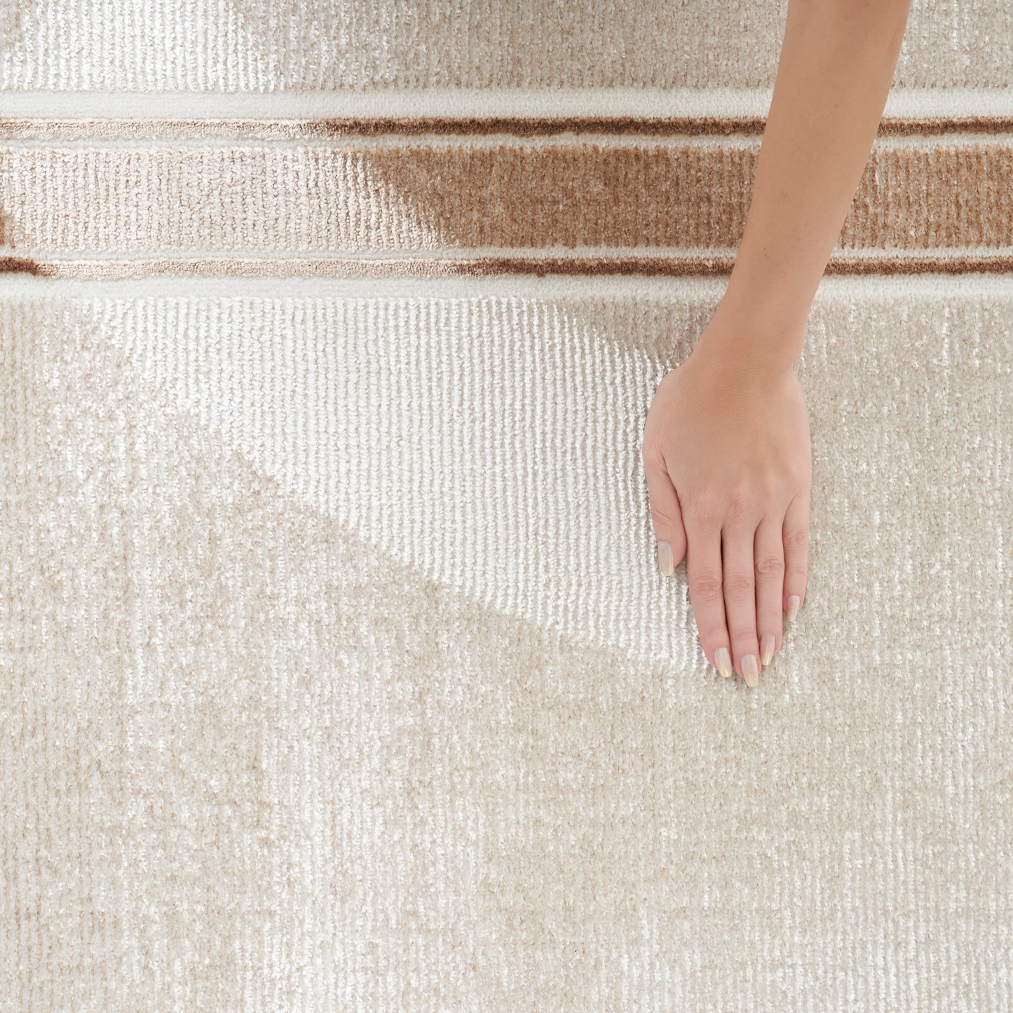 Cream high-pile shag rug with plush texture; hand pressing surface to highlight softness for neutral home decor.