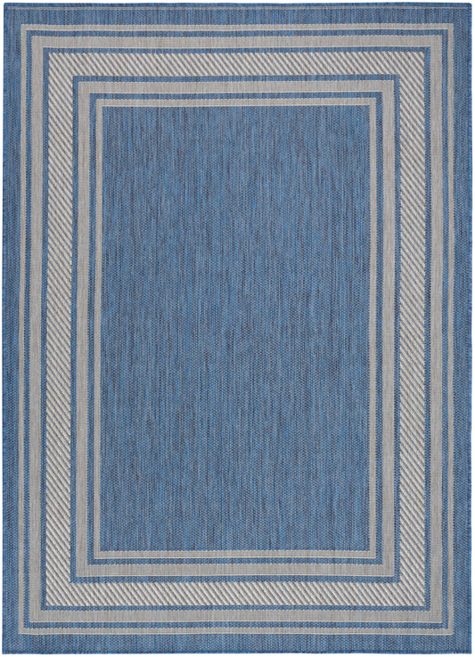 Blue rectangular rug with beige and light-blue nested borders; denim-like weave, geometric pattern.