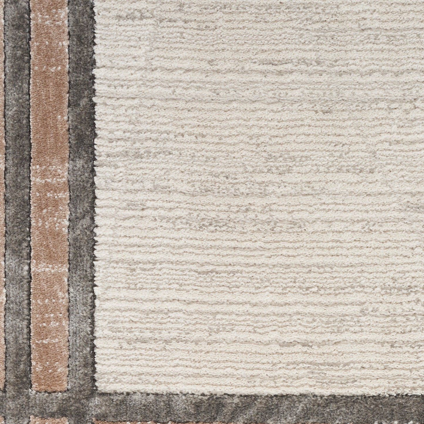 Beige modern area rug with dark gray border and vertical tan and brown stripes along the left edge; plush woven texture.