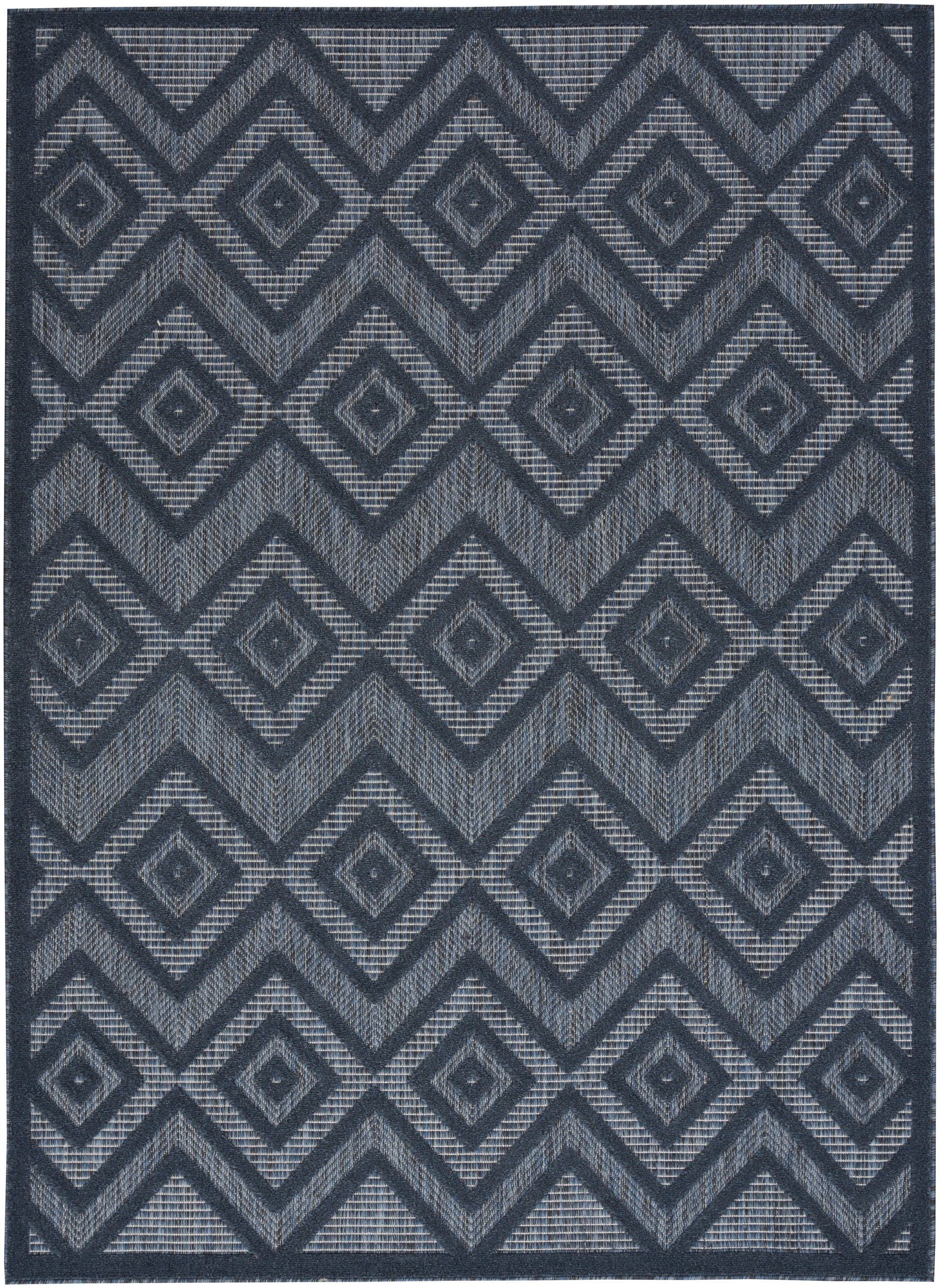 Navy blue rectangular area rug with repeating diamond and chevron geometric pattern in light gray, woven texture.