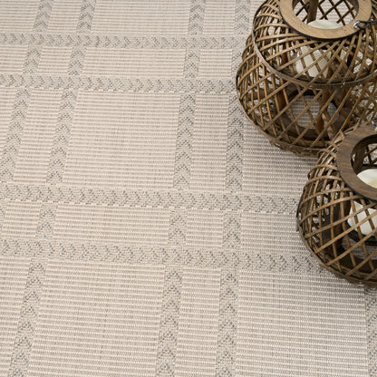 Beige textured woven rug with gray geometric stripes; two brown wicker lanterns on the right.