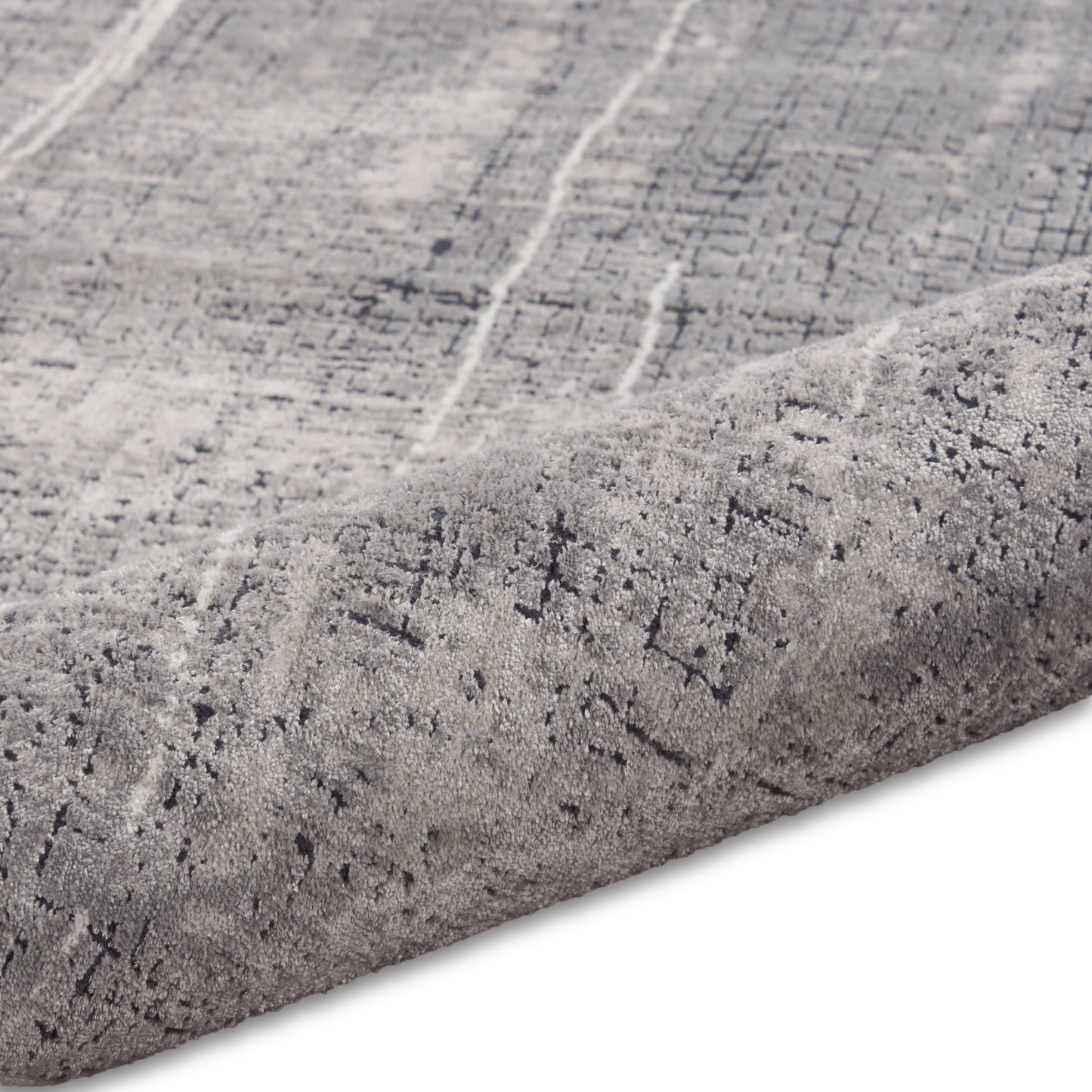 Light gray distressed patterned rug with dark gray lines, plush low-pile, rolled edge.
