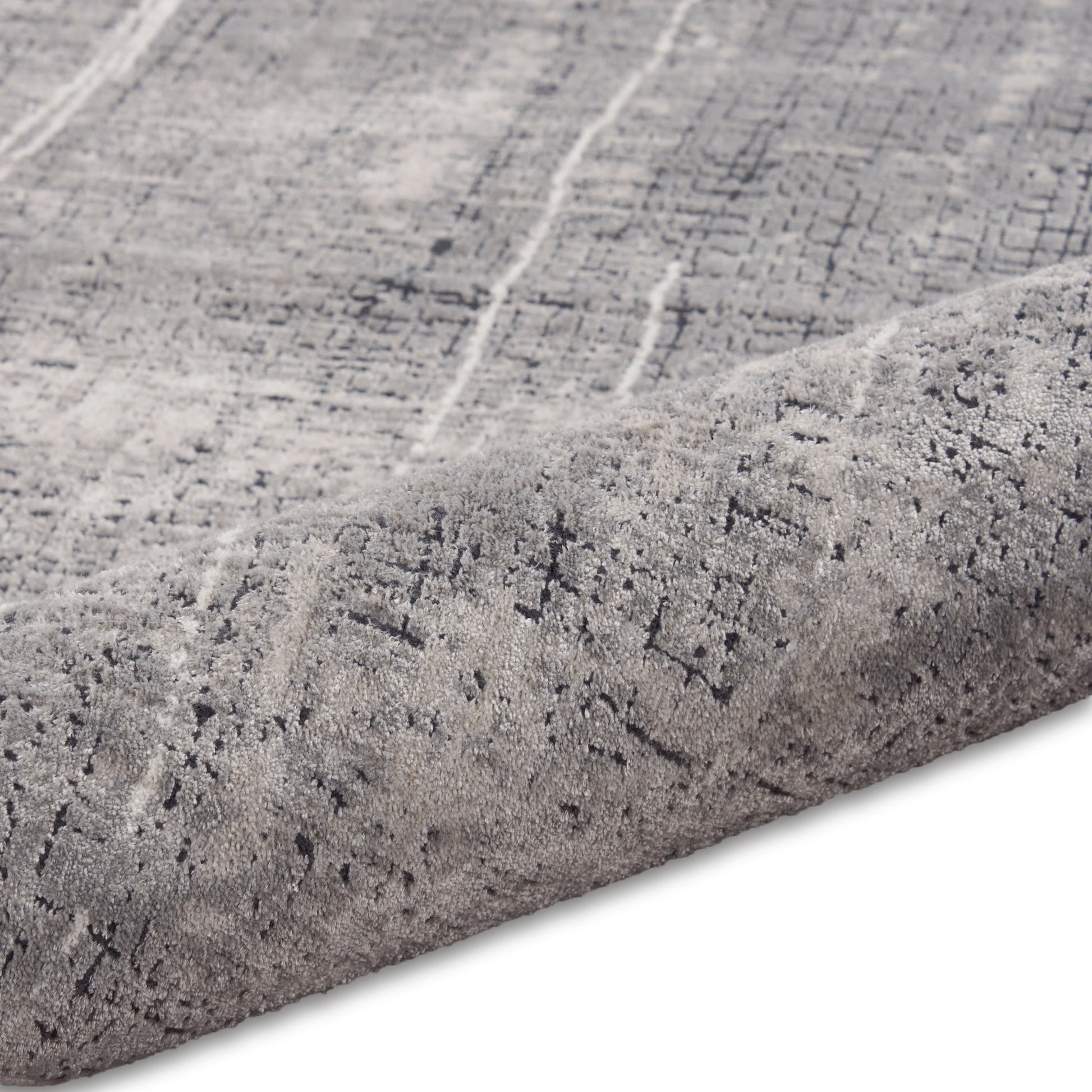 Light gray distressed patterned rug with dark gray lines, plush low-pile, rolled edge.