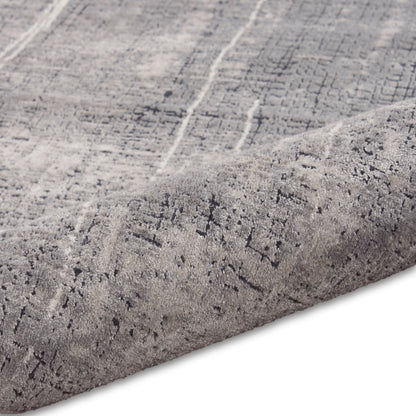 Light gray distressed patterned rug with dark gray lines, plush low-pile, rolled edge.