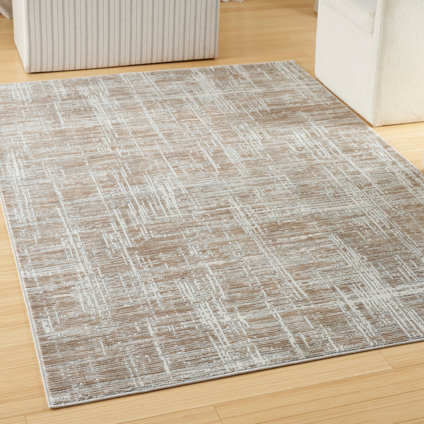 Beige-tan geometric textured area rug on light wood floor.