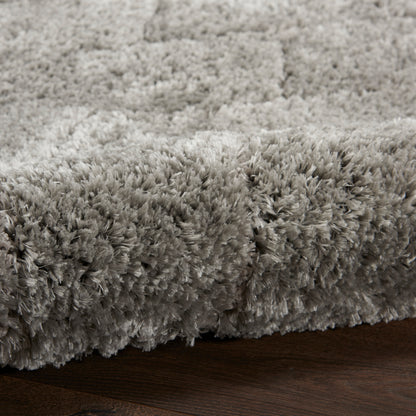 Soft gray high-pile shag rug with plush fibers on dark wood floor.