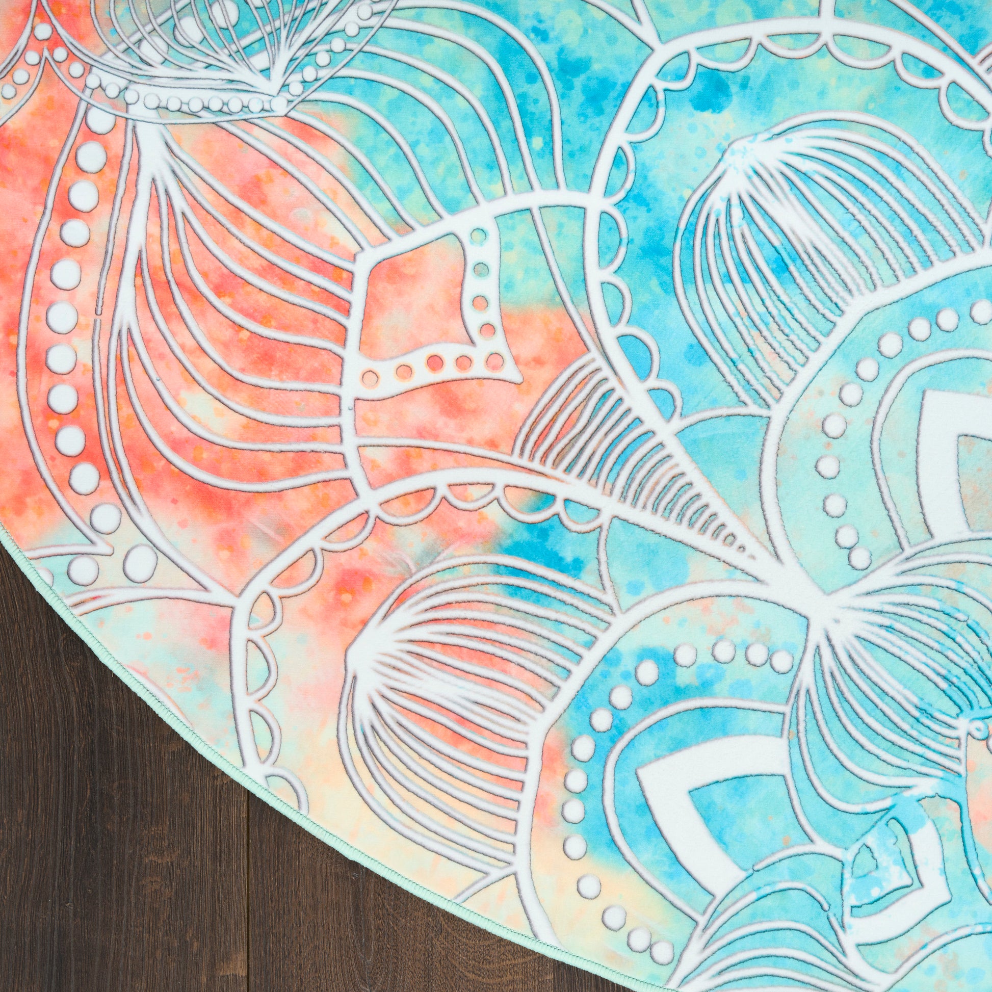 Round boho rug with teal-orange tie-dye and white mandala line art.