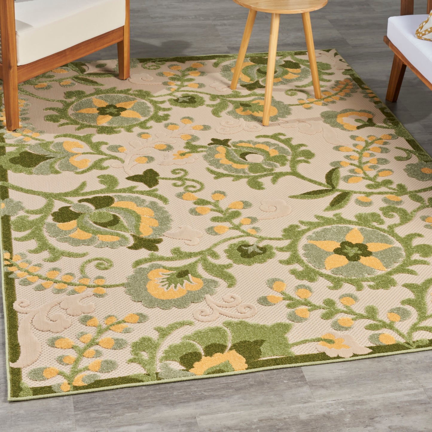 Beige outdoor rug with green & yellow floral vines and ornate scrollwork.