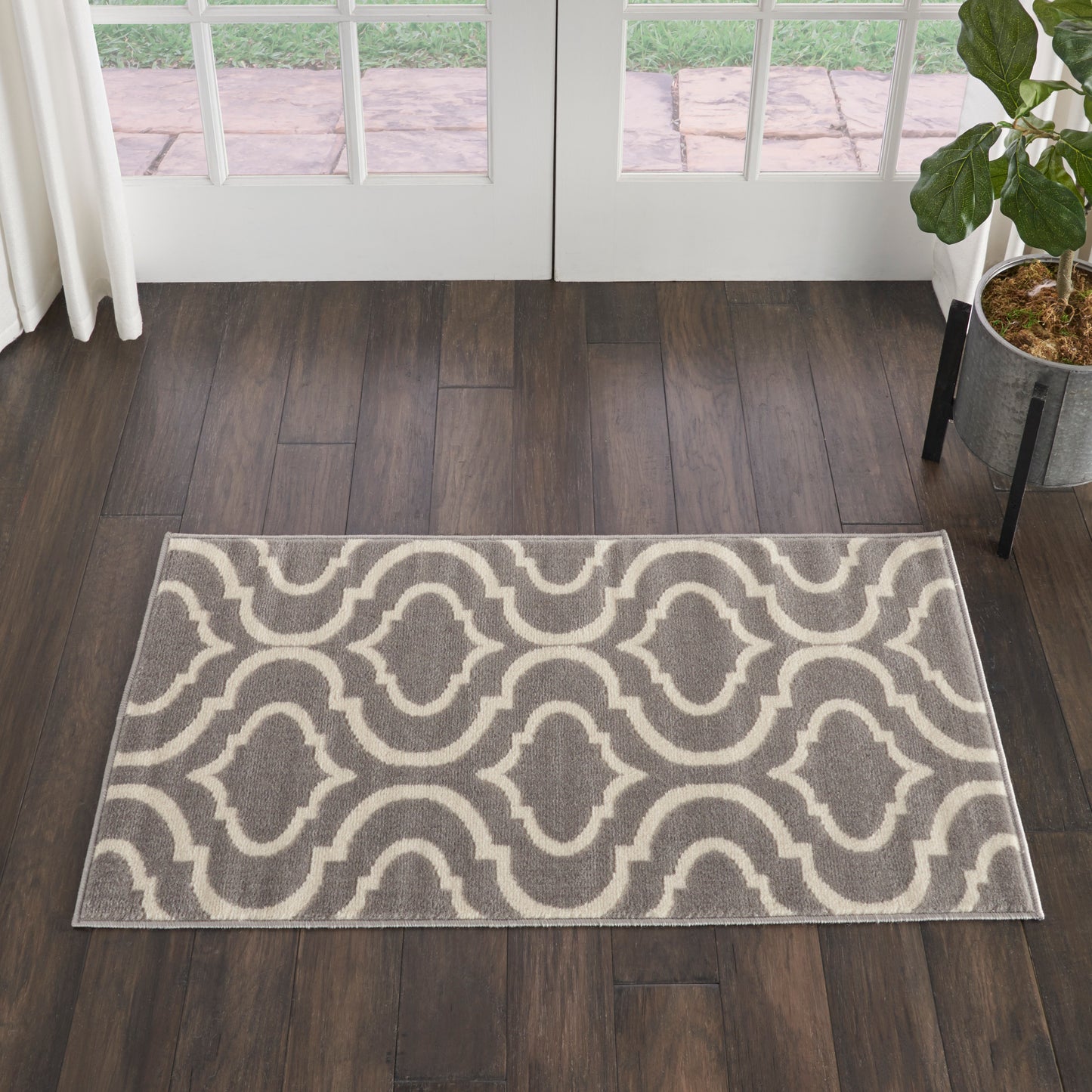 Gray & ivory interlocking curved motif area rug on dark wood floor; modern transitional style.