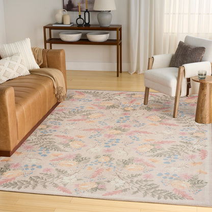 Pastel floral area rug in a bright living room with a tan leather sofa, light gray armchair, and wooden console.