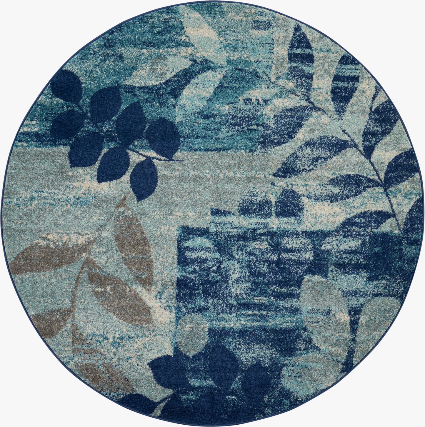 Circular rug with blue botanical leaves in navy and teal over a muted beige background.