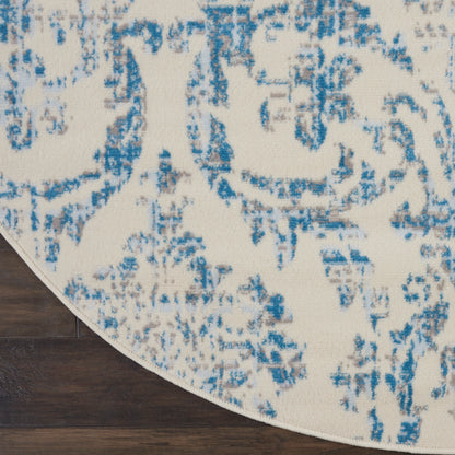 Round cream rug with blue distressed floral pattern; soft low-pile texture for living room decor.