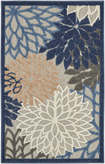 Rectangular area rug with large white, tan and light-blue floral motifs on a blue field and navy border.