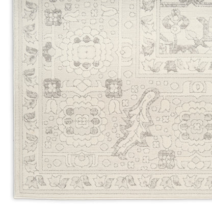 Cream-toned area rug with muted floral medallions and decorative border.