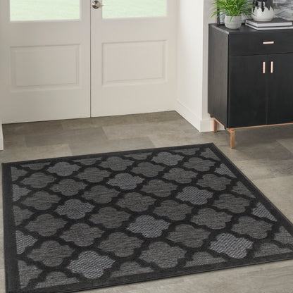 Square black and gray entryway rug with a woven quatrefoil lattice pattern.