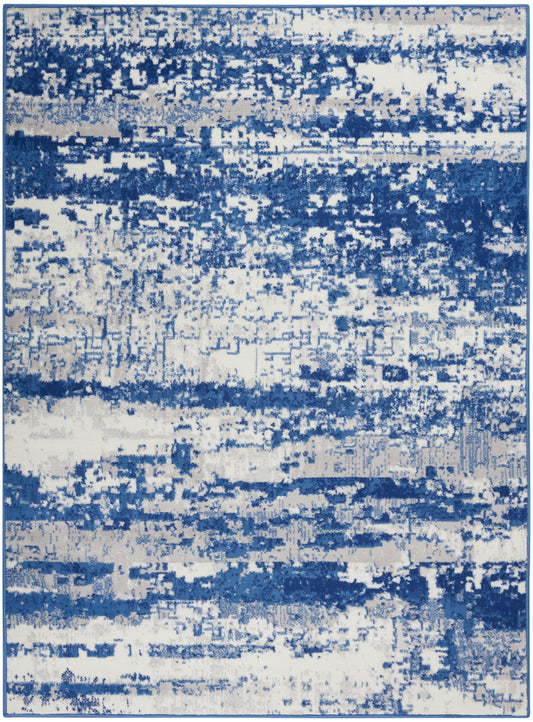 Rectangular area rug with abstract blue and white brushstroke pattern; modern coastal style, woven texture.