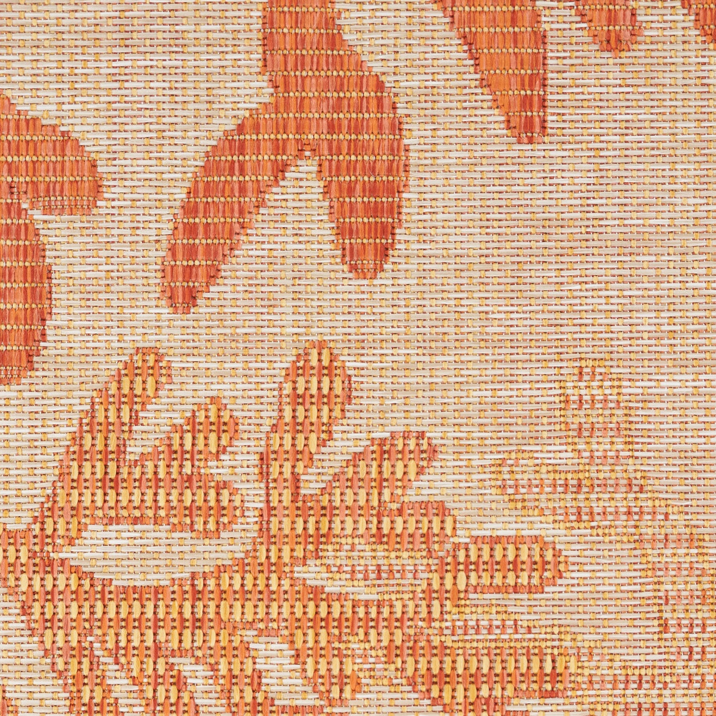 Close-up of orange floral jacquard weave on beige rug; textured decorative textile.