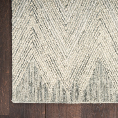 Beige and gray chevron rug on dark wood floor, soft textured pile with geometric zigzag pattern.
