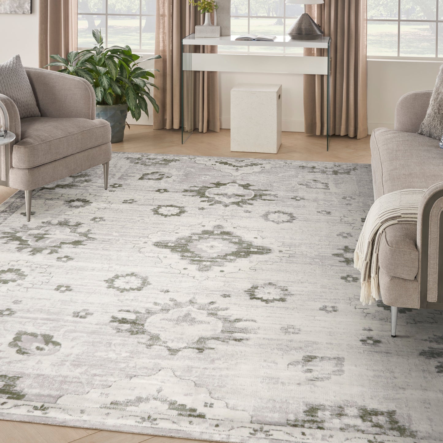 Light gray oriental-style area rug with muted sage-green floral medallions in a contemporary living room.