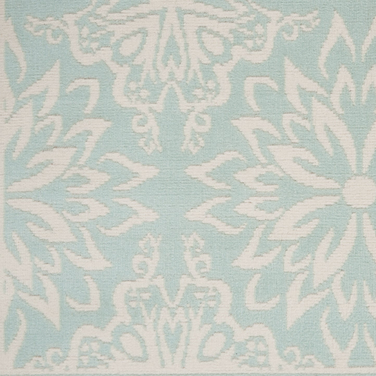 Light blue rug with a white damask floral pattern; 6' x 9'.