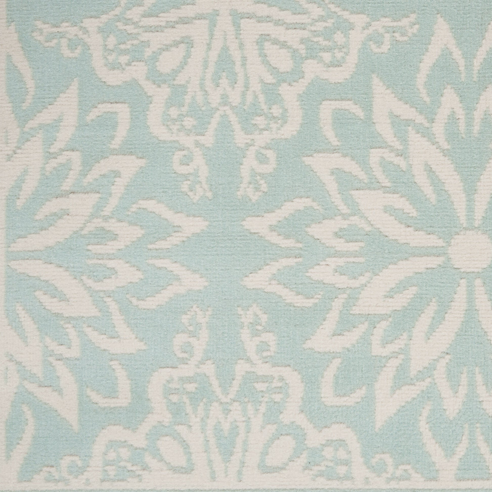 Light blue rug with a white damask floral pattern; 6' x 9'.