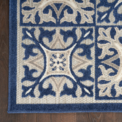 Navy blue & cream damask patterned area rug with a thick navy border on a wood floor.