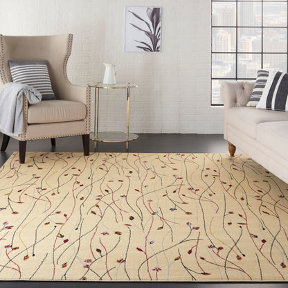 Cream rug with multicolored vines in a beige living room, complemented by a tufted armchair, light sofa and a gold-framed glass side table.