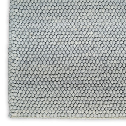Light gray loop-pile rug close-up with dense soft microfiber tufts.