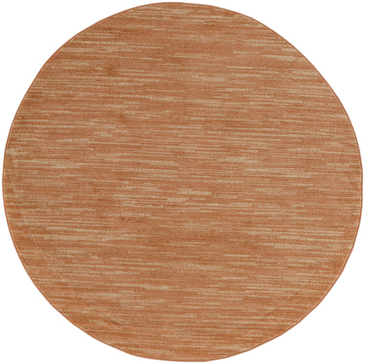 Round copper-bronze outdoor area rug with subtle brushed texture.
