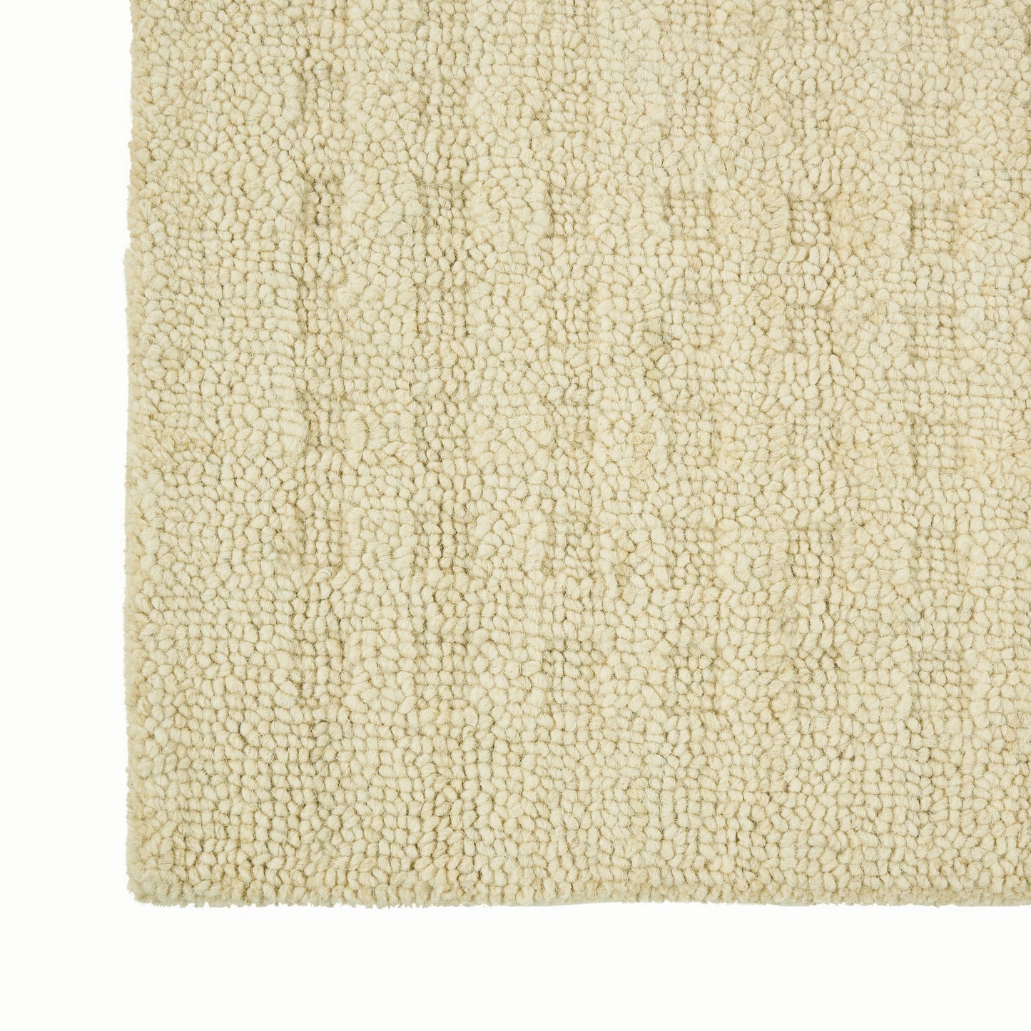 Beige plush shag rug corner with dense boucle texture and soft, cozy fibers.