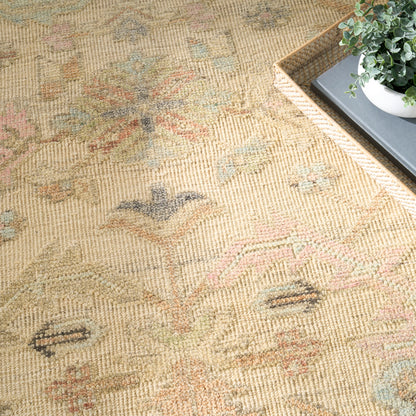 Beige oriental rug with pastel blue, pink and green motifs; textured woven pile, shown beside a wicker tray with a plant.