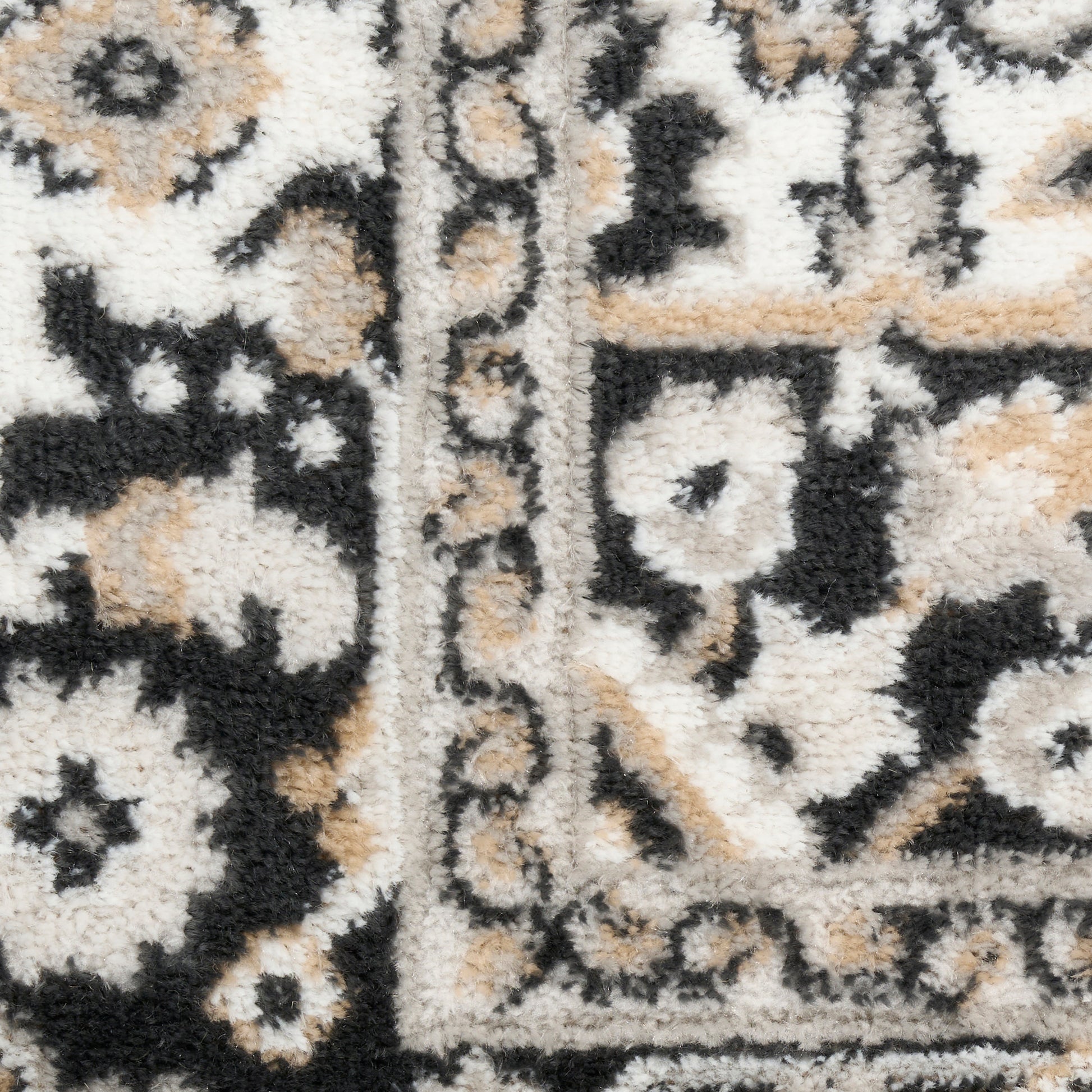 Persian-style rug in cream, black and tan with ornate floral border and plush shag pile.