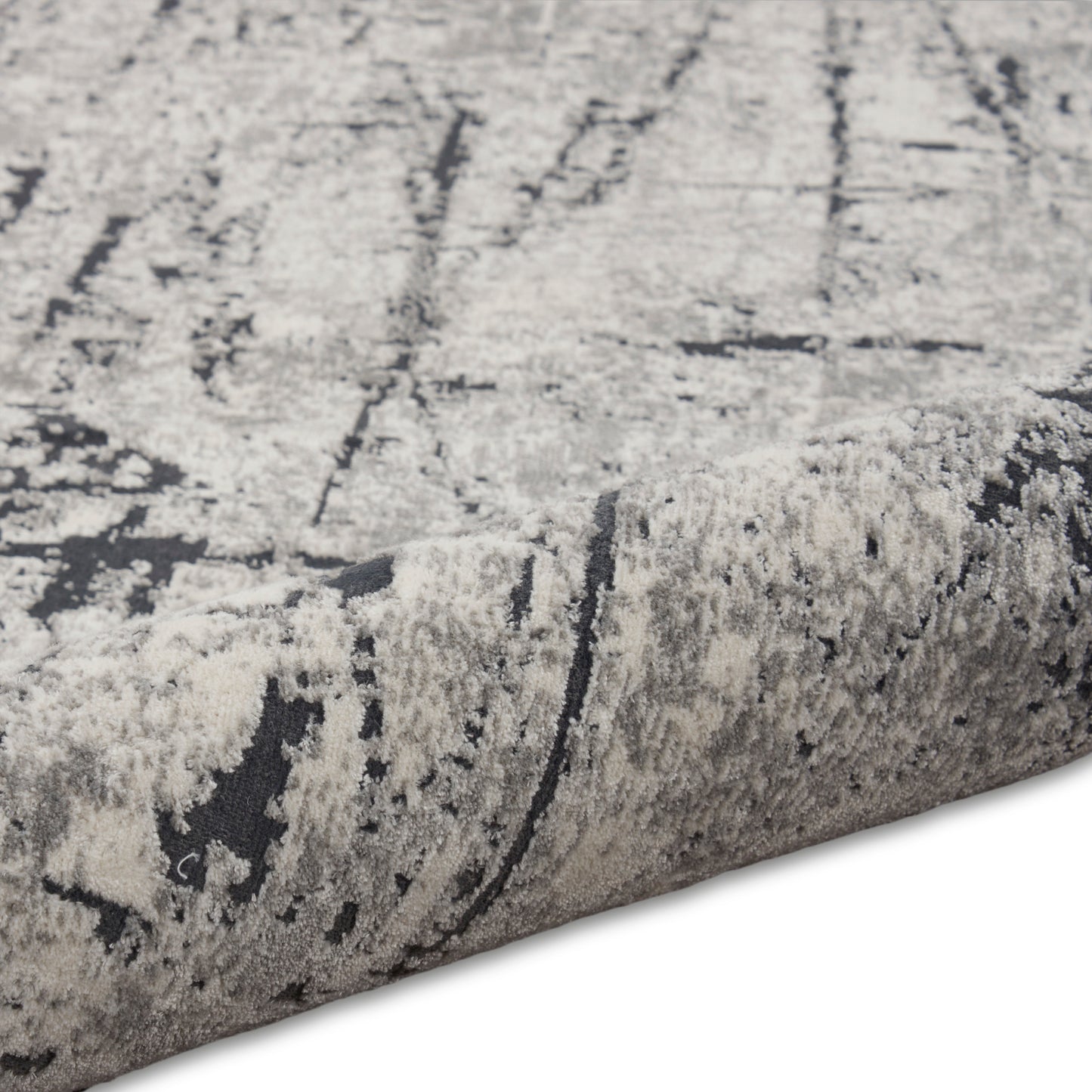 Abstract gray and ivory rug with plush pile and rolled edge, modern geometric pattern.