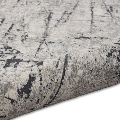 Abstract gray and ivory rug with plush pile and rolled edge, modern geometric pattern.