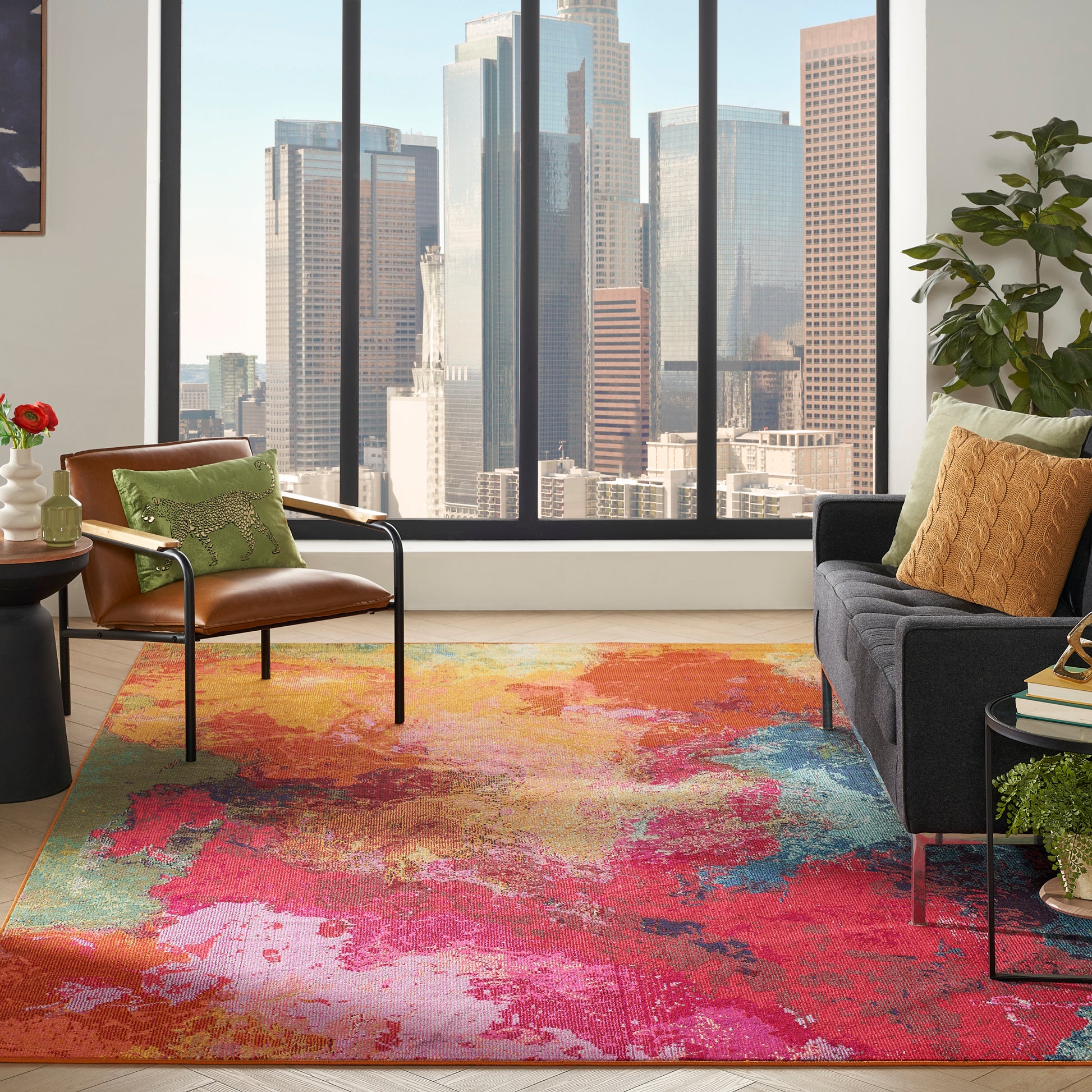 Bright urban living room with vibrant abstract rug, leather lounge chair, dark sofa, colorful pillows, and city skyline view.