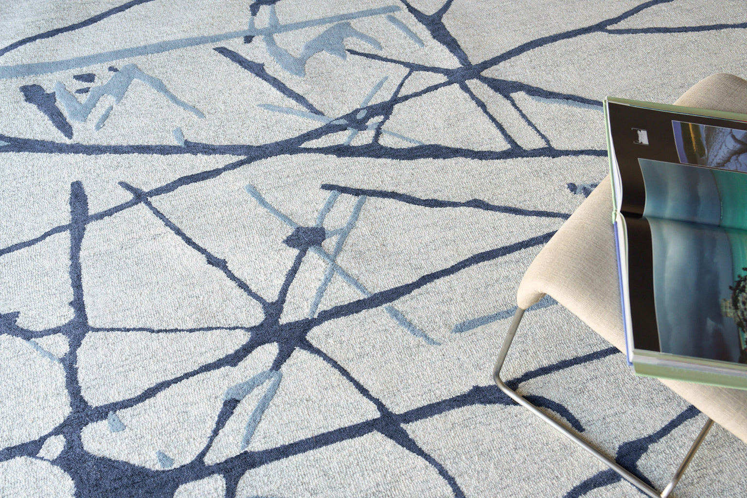 Soft gray rug with a navy abstract line pattern.