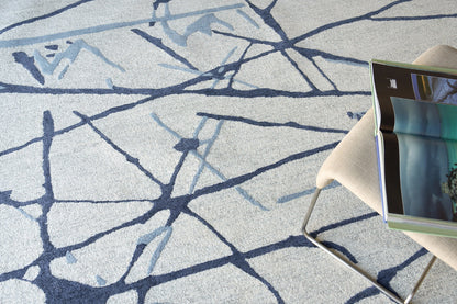 Soft gray rug with a navy abstract line pattern.