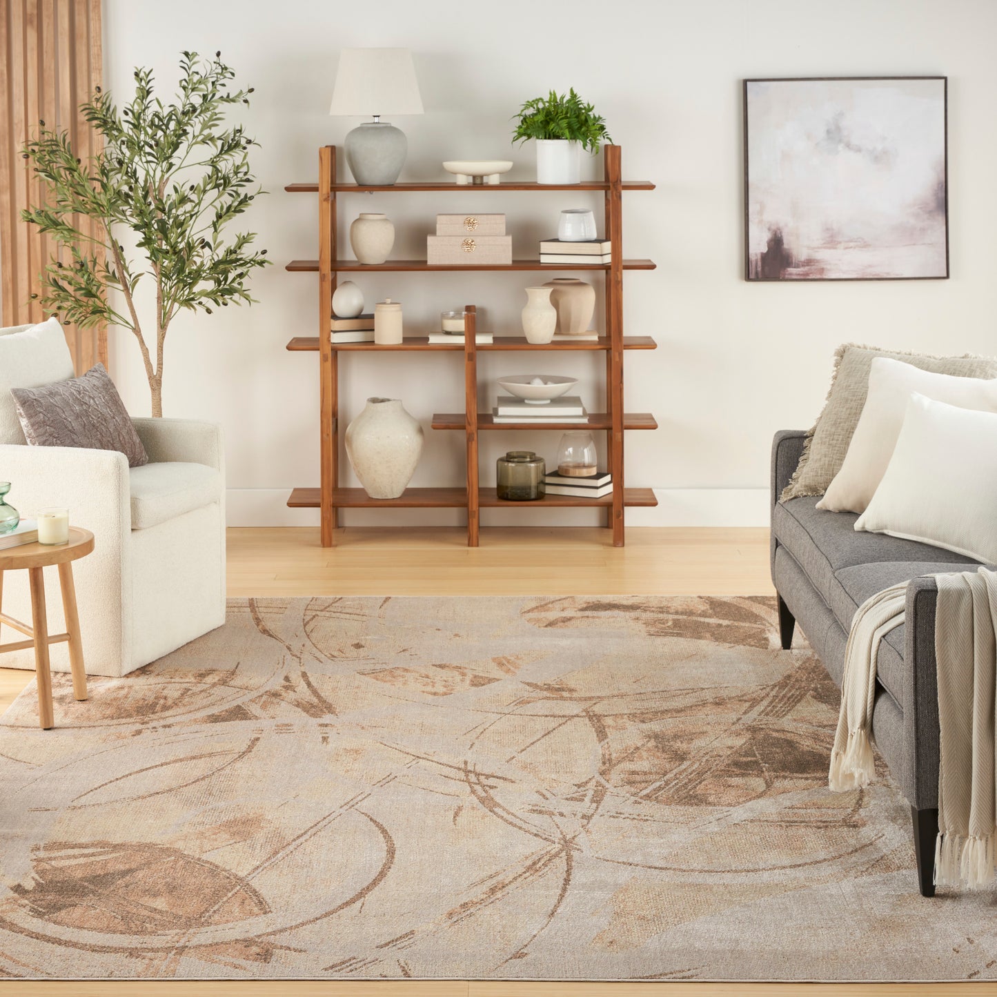 Cozy living room with a tall wood open bookshelf, ceramic vases, books, a plant, beige area rug, and beige/gray sofas.