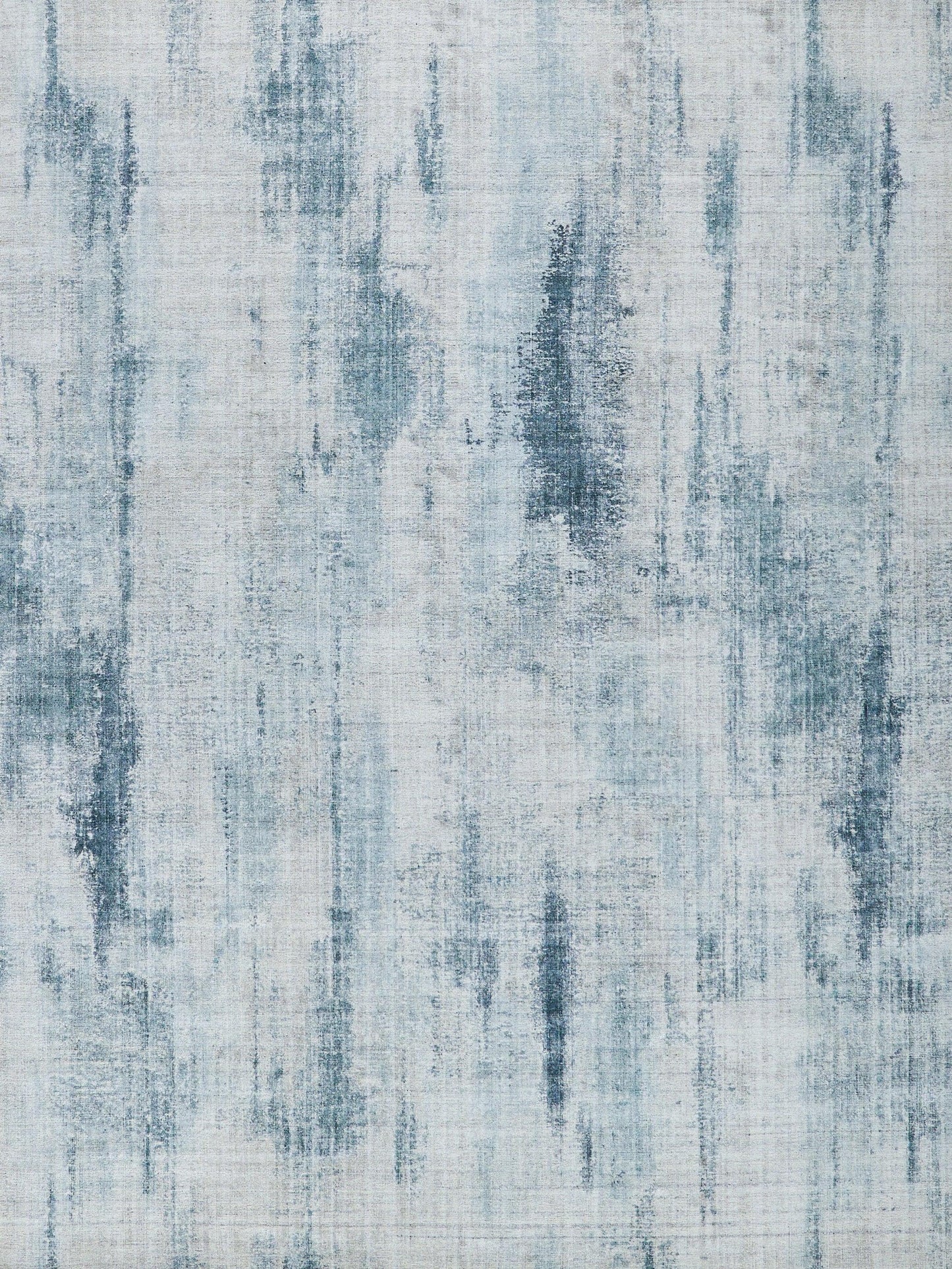Abstract blue-gray area rug with vertical brushstroke pattern; cool denim tones, modern decor accent.