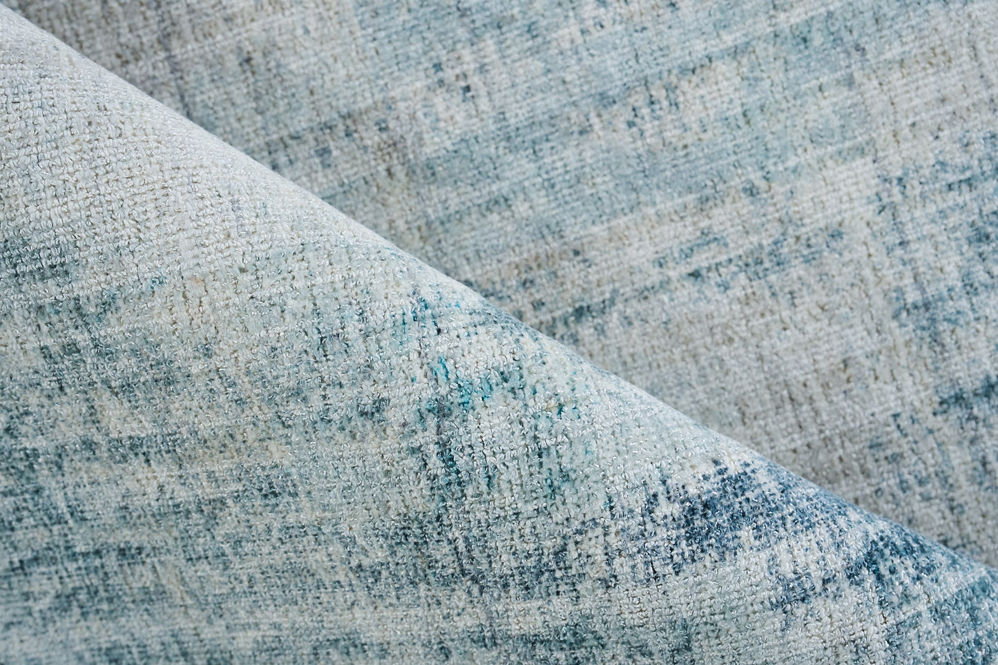 Blue-gray woven fabric close-up with mottled texture, ideal for upholstery or rug.