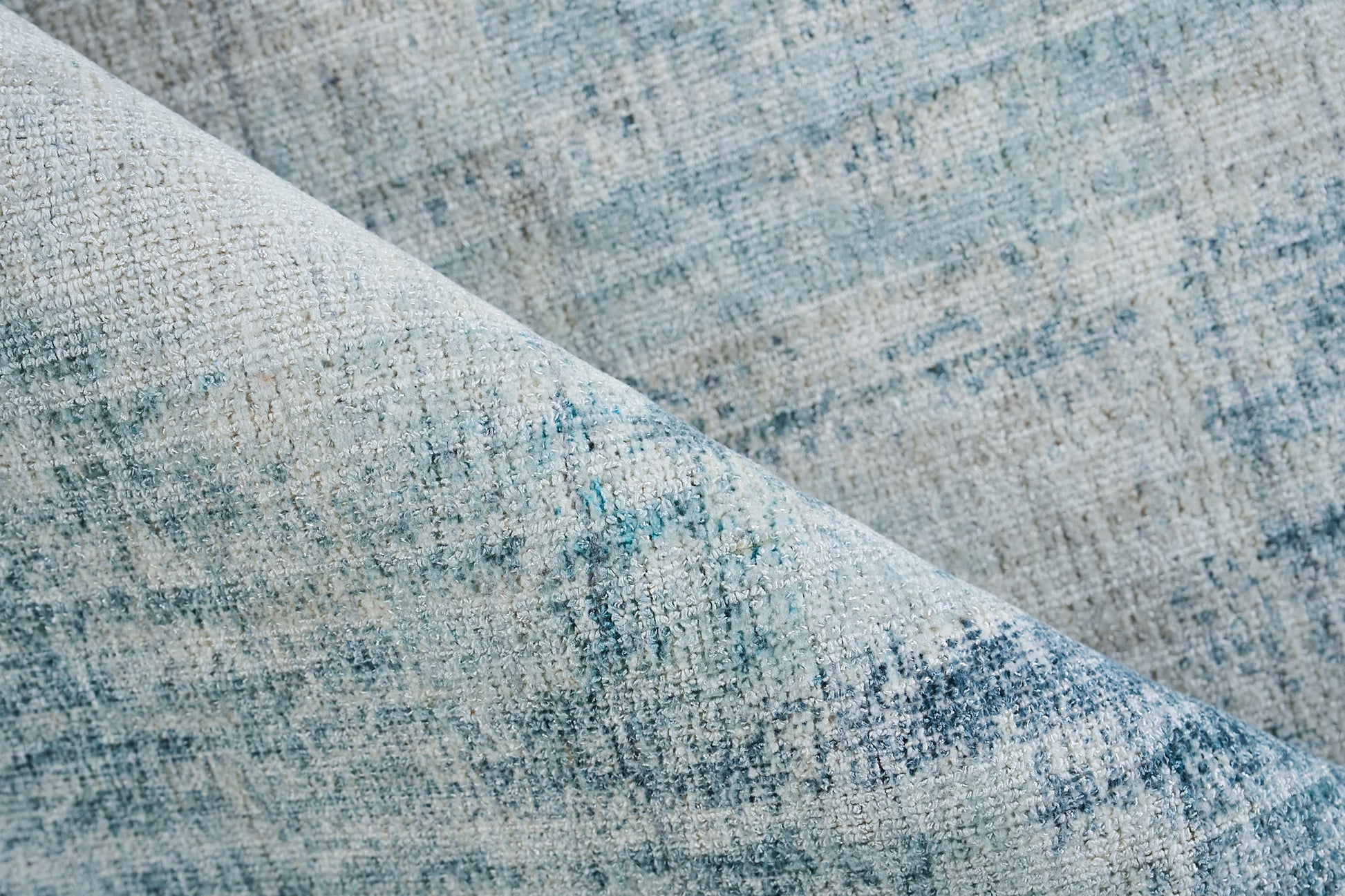 Blue-gray woven fabric close-up with mottled texture, ideal for upholstery or rug.