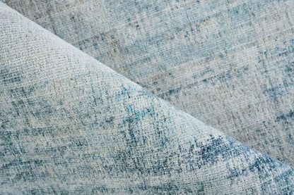 Blue-gray woven fabric close-up with mottled texture, ideal for upholstery or rug.