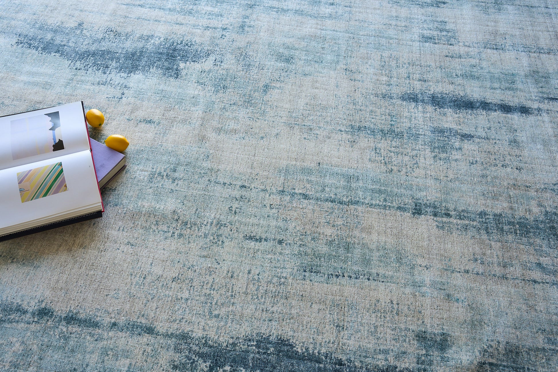 Open notebook with yellow pencils on a blue abstract-patterned area rug.