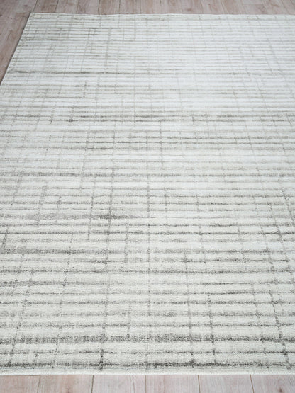Light gray rectangular area rug with subtle darker grid lines; modern minimalist style on a wooden floor.