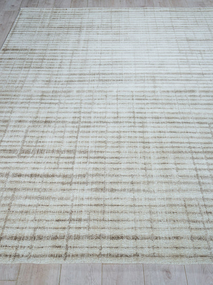 Beige hand-loomed rug with a subtle taupe grid pattern on a cream background; modern distressed look.